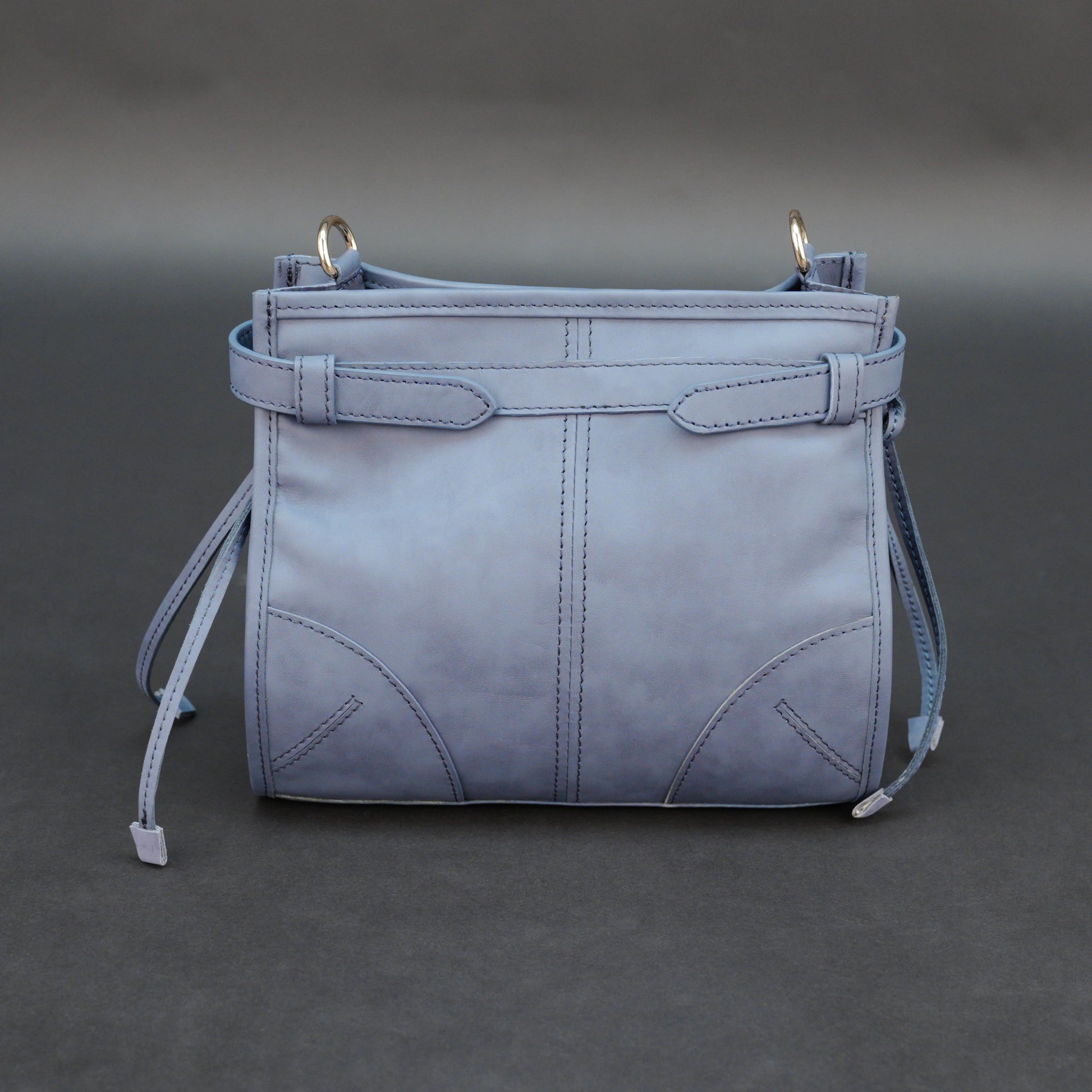 Light blue cow leather bag with shoulder strap, main compartment, and inner pockets.