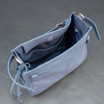 Light blue cow leather bag with shoulder strap, main compartment, and inner pockets.