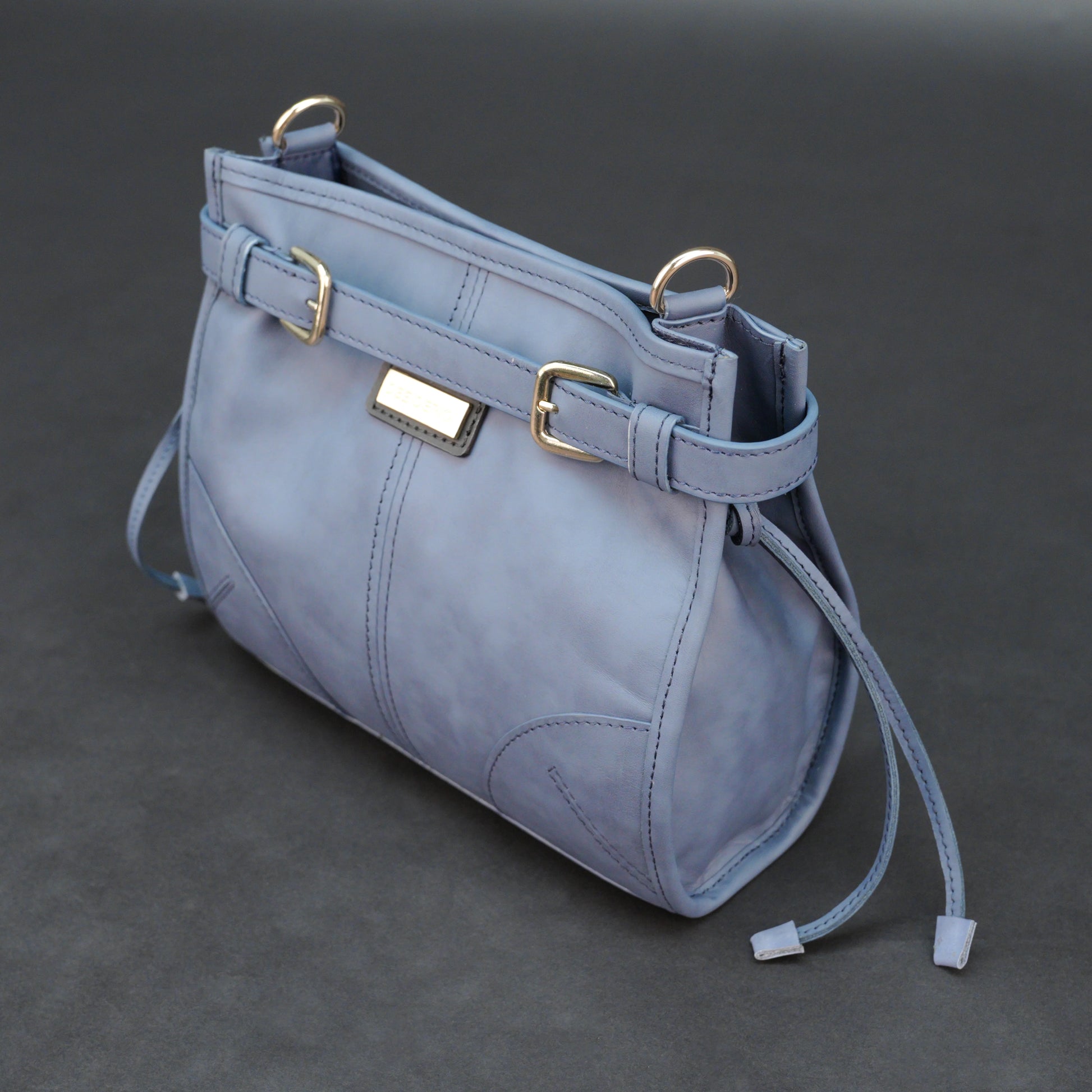 Light blue cow leather bag with shoulder strap, main compartment, and inner pockets.
