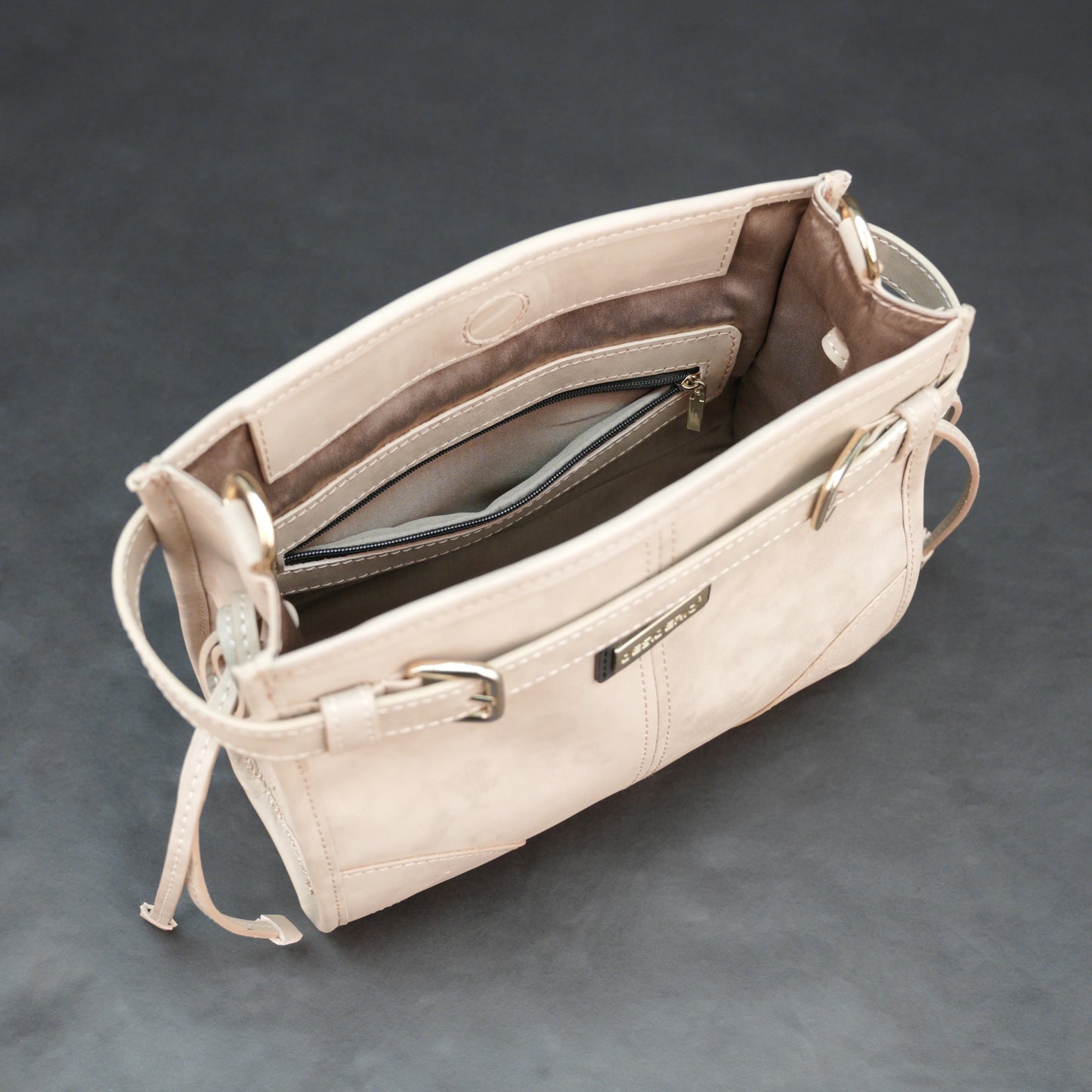 Cream cow Manisota leather bag with shoulder strap and pockets.