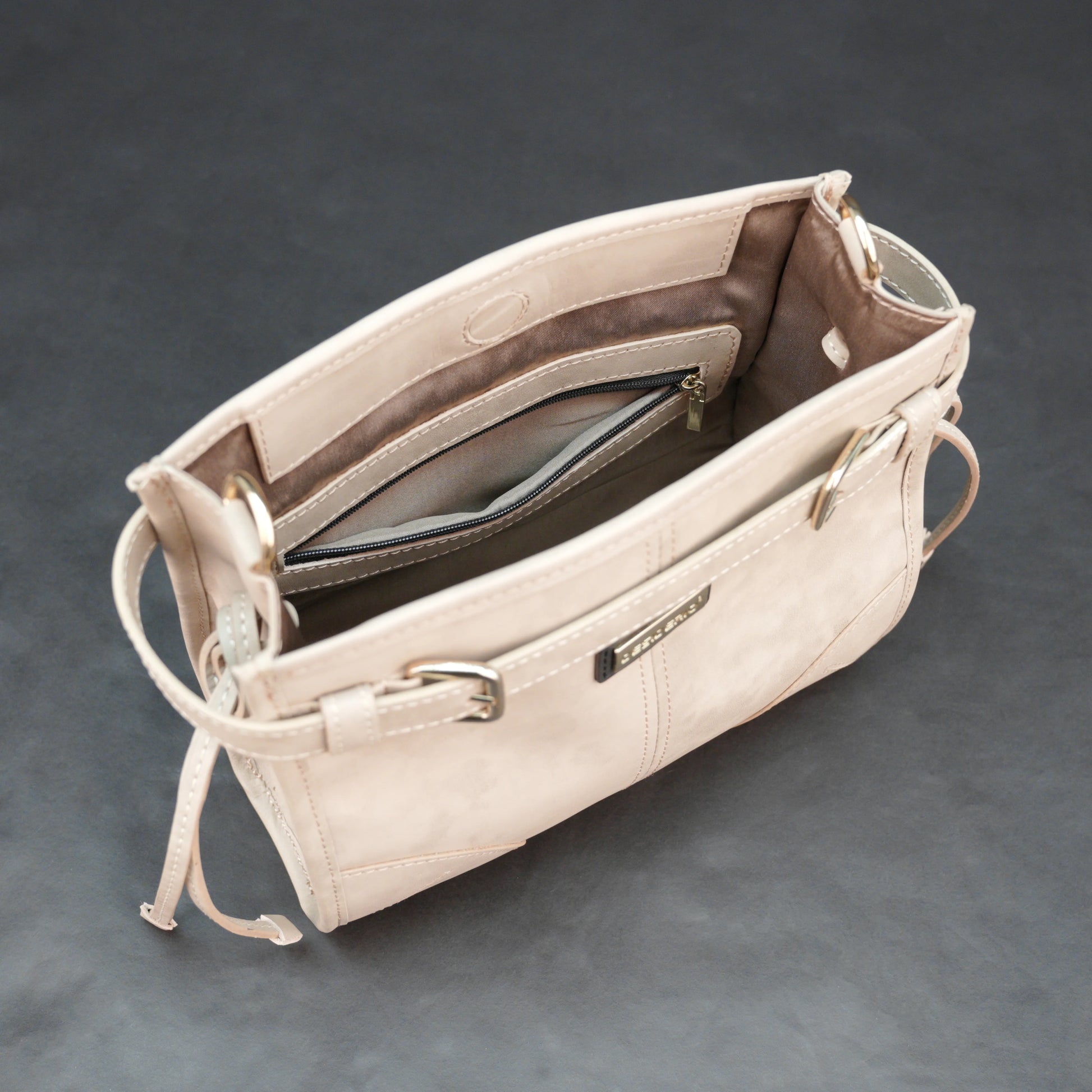 Cream cow Manisota leather bag with shoulder strap and pockets.