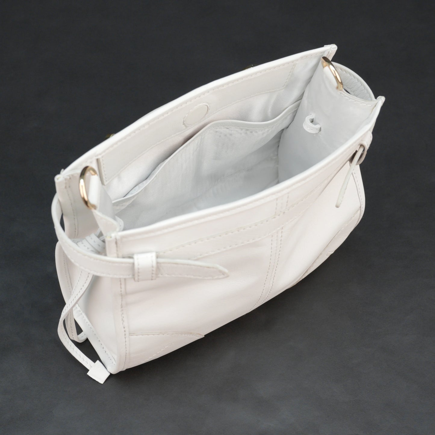White sheep leather bag with shoulder strap and pockets.