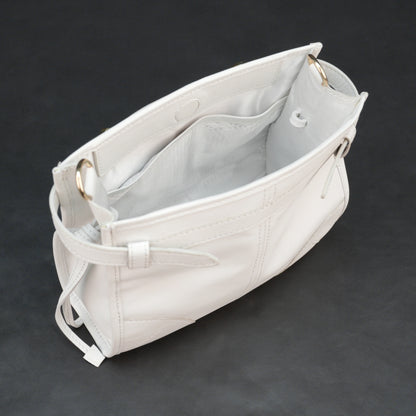 White sheep leather bag with shoulder strap and pockets.