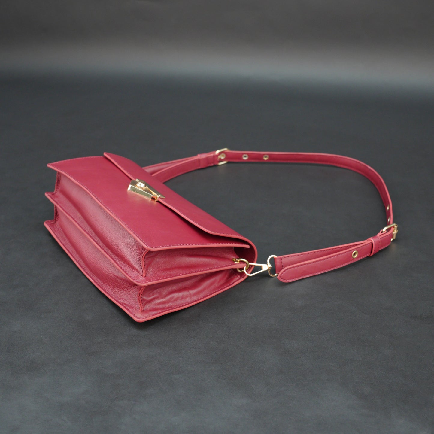 Maroon sheep leather bag with chain strap and zipper pocket.