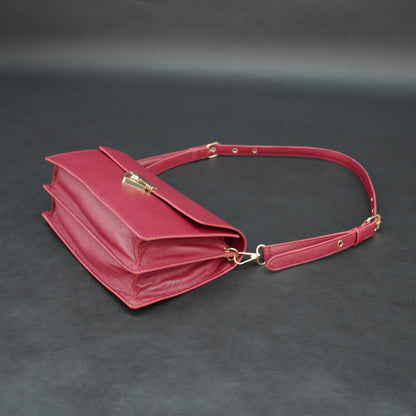 Maroon sheep leather bag with chain strap and zipper pocket.