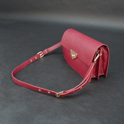 Maroon sheep leather bag with chain strap and zipper pocket.