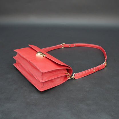 Red sheep leather bag with chain strap, two compartments, and zipper pocket.