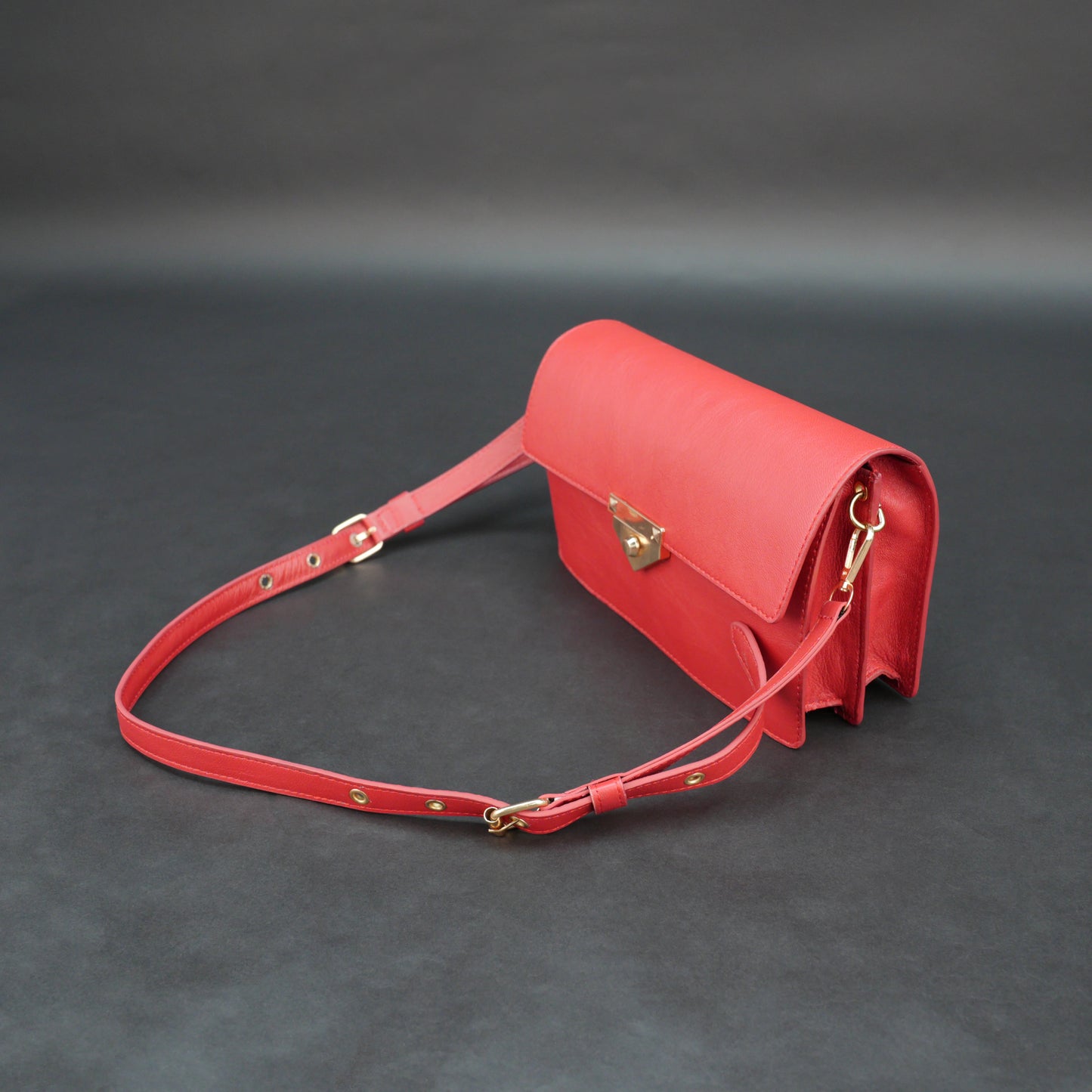 Red sheep leather bag with chain strap, two compartments, and zipper pocket.