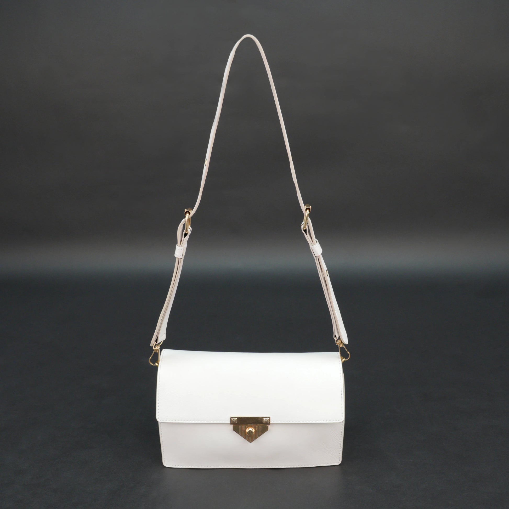 White sheep leather bag with chain strap, two compartments, and zipper pocket.