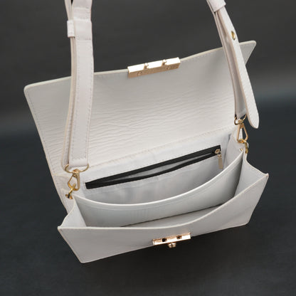 White sheep leather bag with chain strap, two compartments, and zipper pocket.
