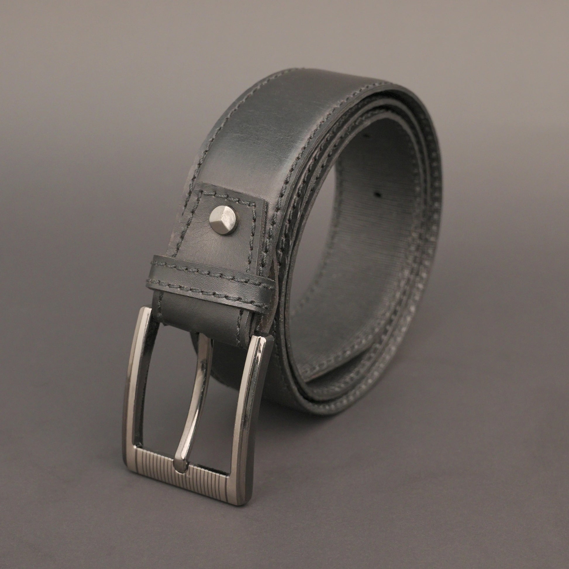 Premium leather belt with solid one-piece construction, charcoal metal buckle, durable, adjustable, stylish for jeans and dress wear