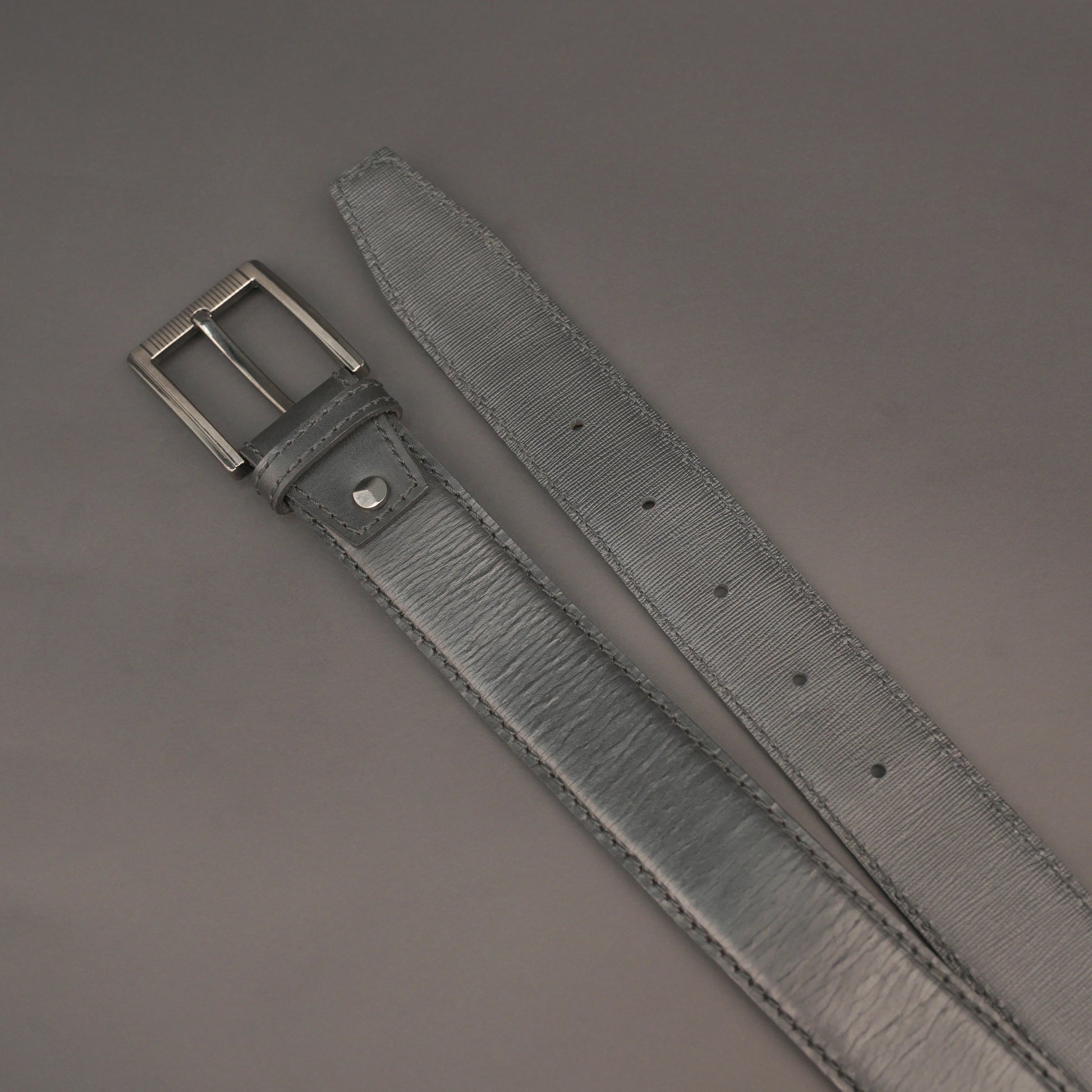 Premium leather belt with solid one-piece construction, charcoal metal buckle, durable, adjustable, stylish for jeans and dress wear