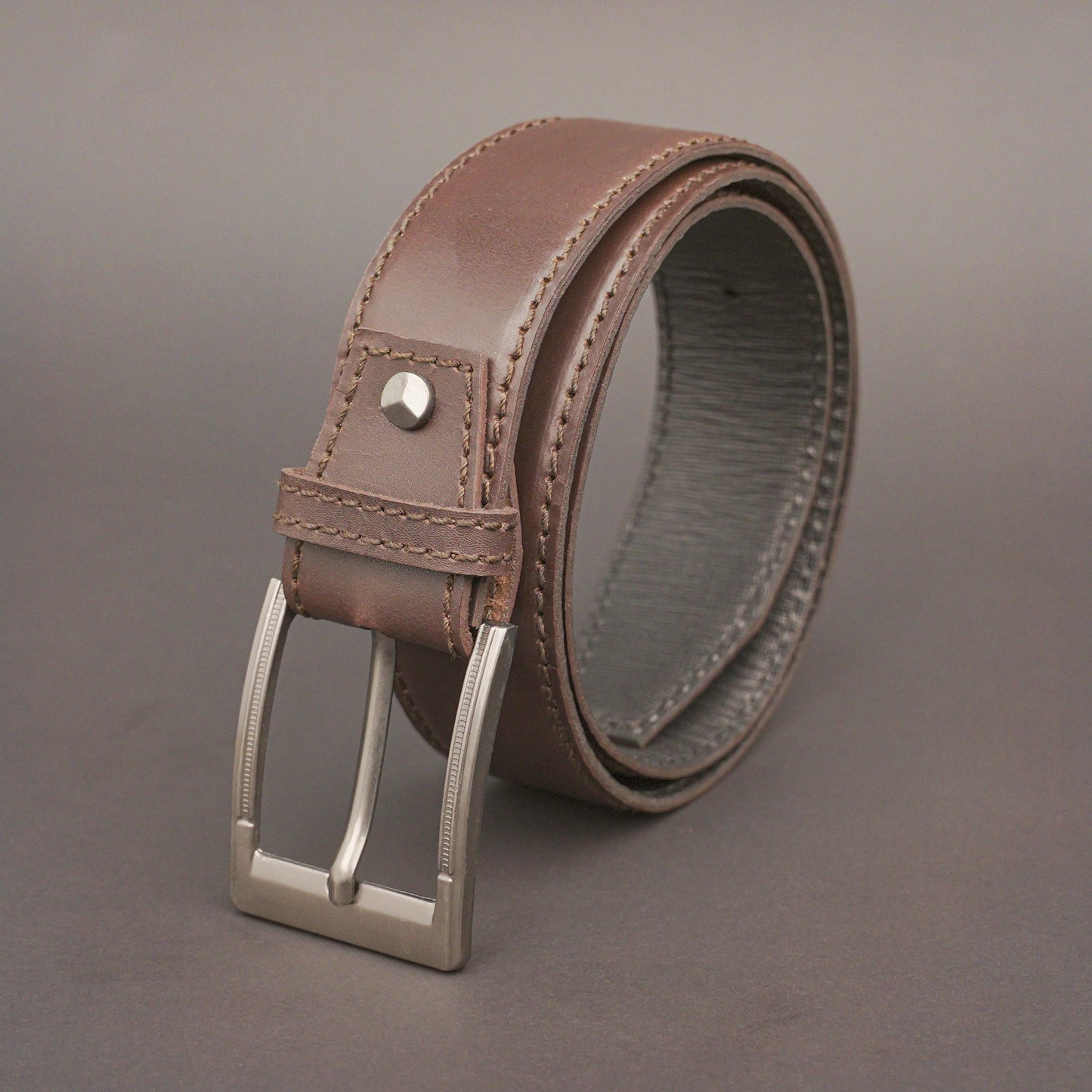 Premium leather belt with solid one-piece construction, charcoal metal buckle, durable, adjustable, stylish for jeans and dress wear