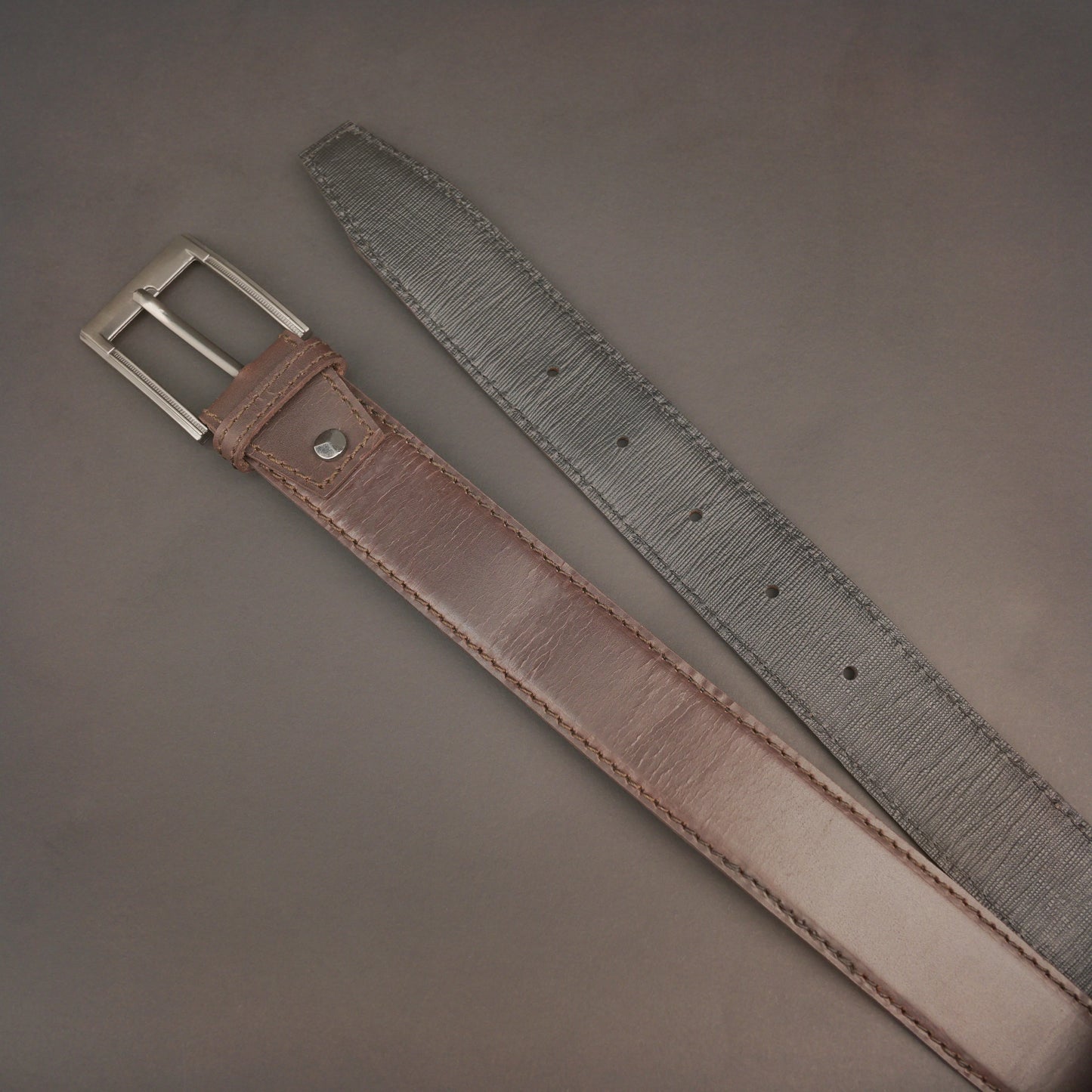 Premium leather belt with solid one-piece construction, charcoal metal buckle, durable, adjustable, stylish for jeans and dress wear