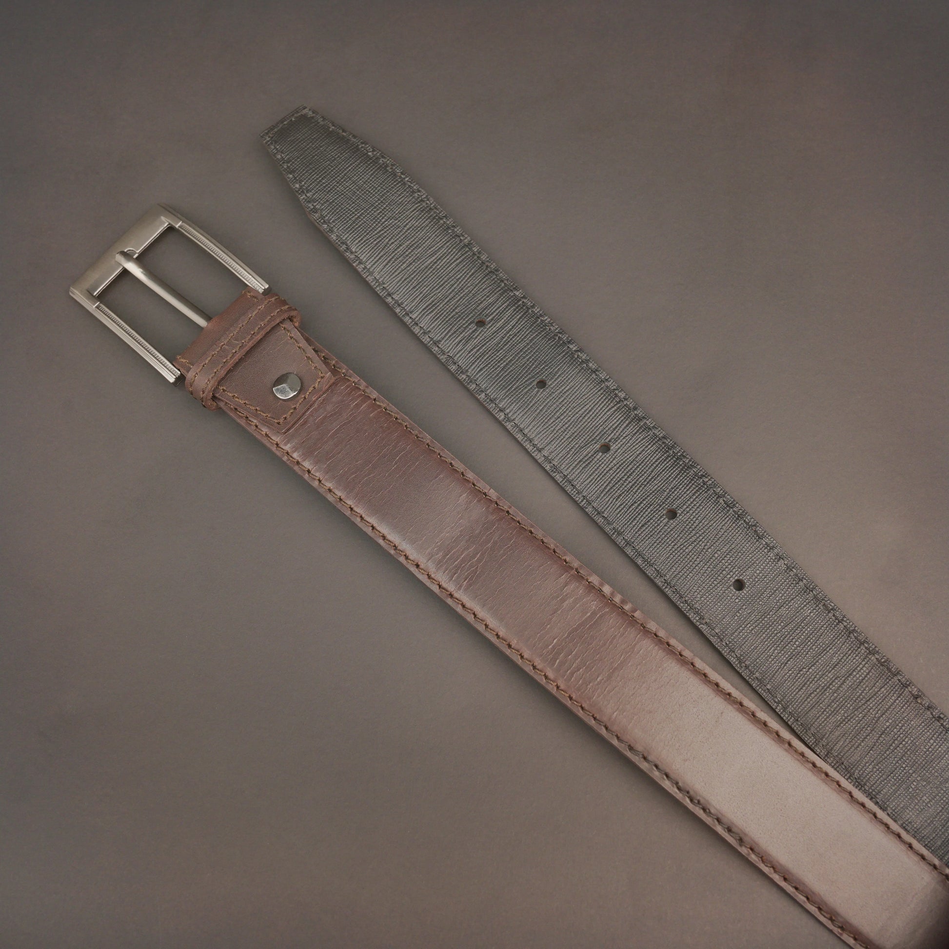 Premium leather belt with solid one-piece construction, charcoal metal buckle, durable, adjustable, stylish for jeans and dress wear