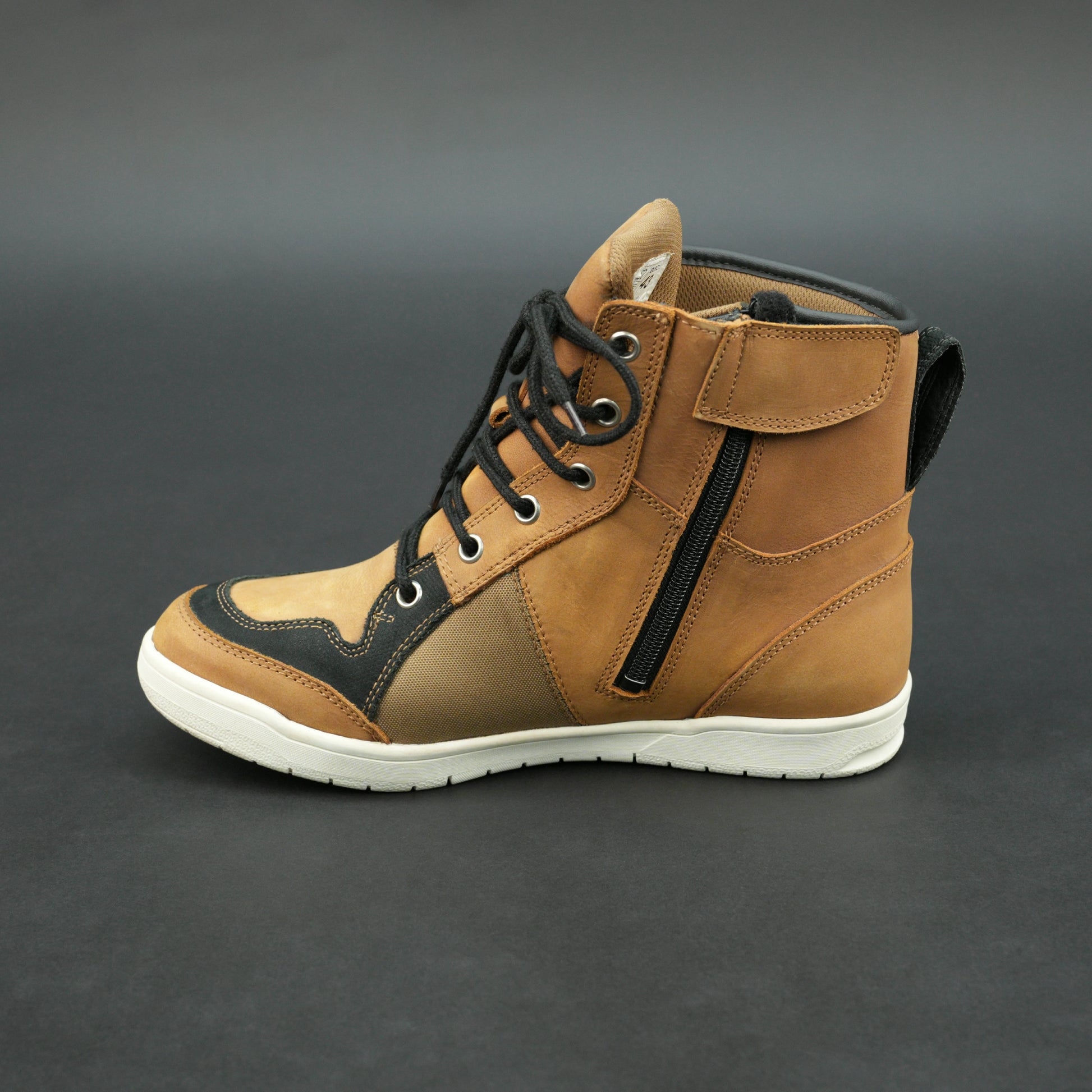 Tan and black motorbike boots with mesh panels and white sole.