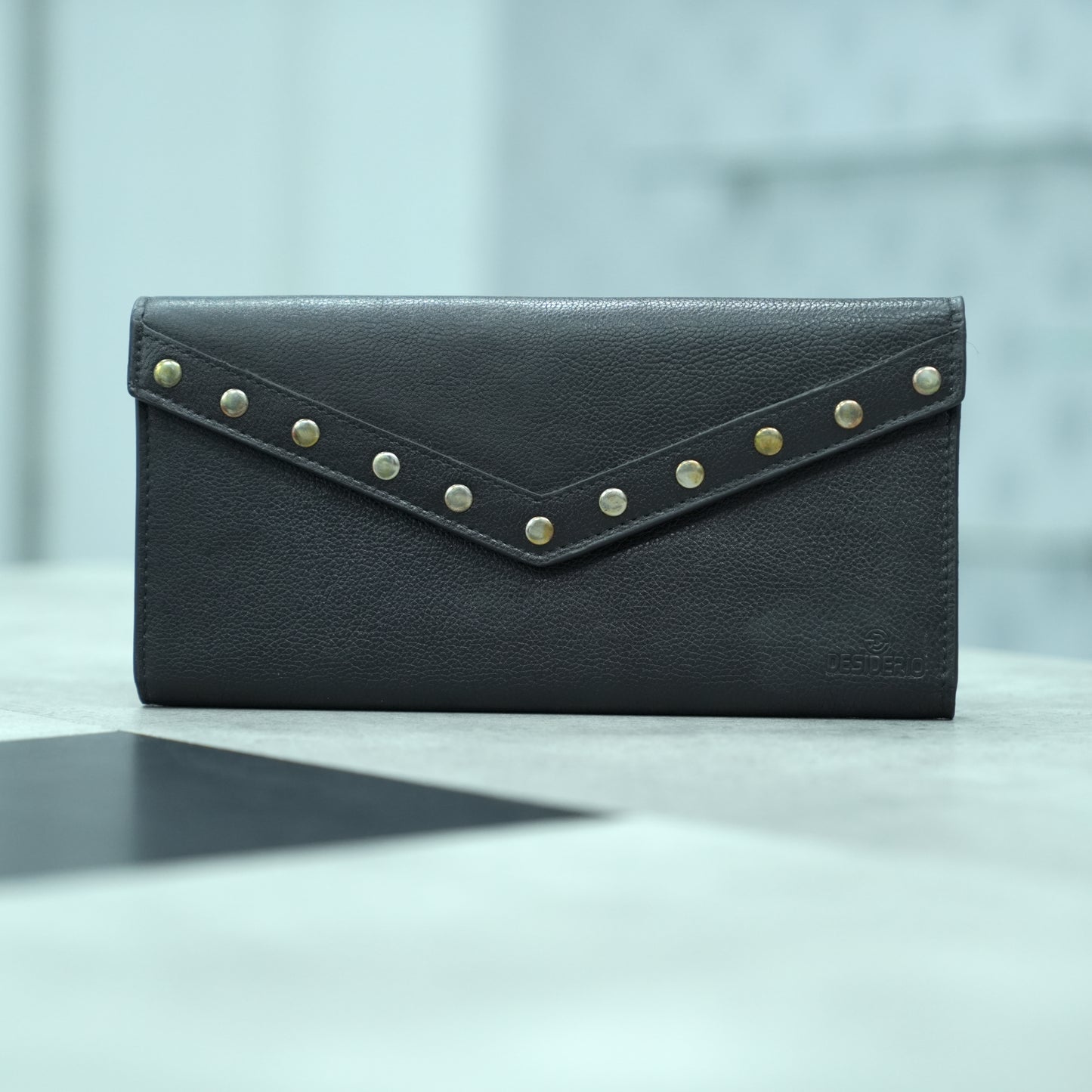 Black leather clutch with three main compartments, one zip pocket, and three card pockets for organized storage