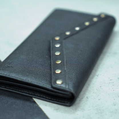 Black leather clutch with three main compartments, one zip pocket, and three card pockets for organized storage