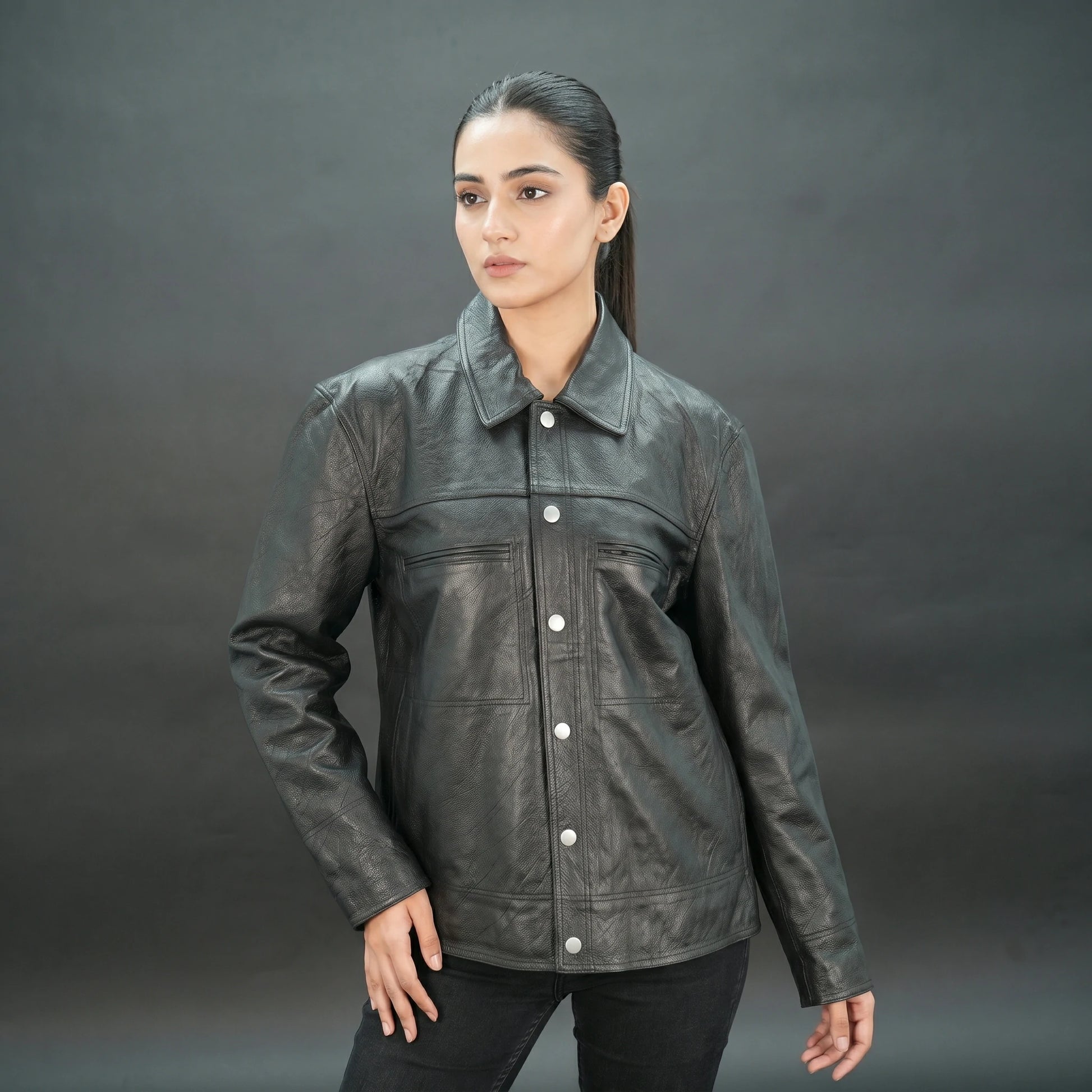 Black leather jacket with spread collar, button closure, and relaxed fit.