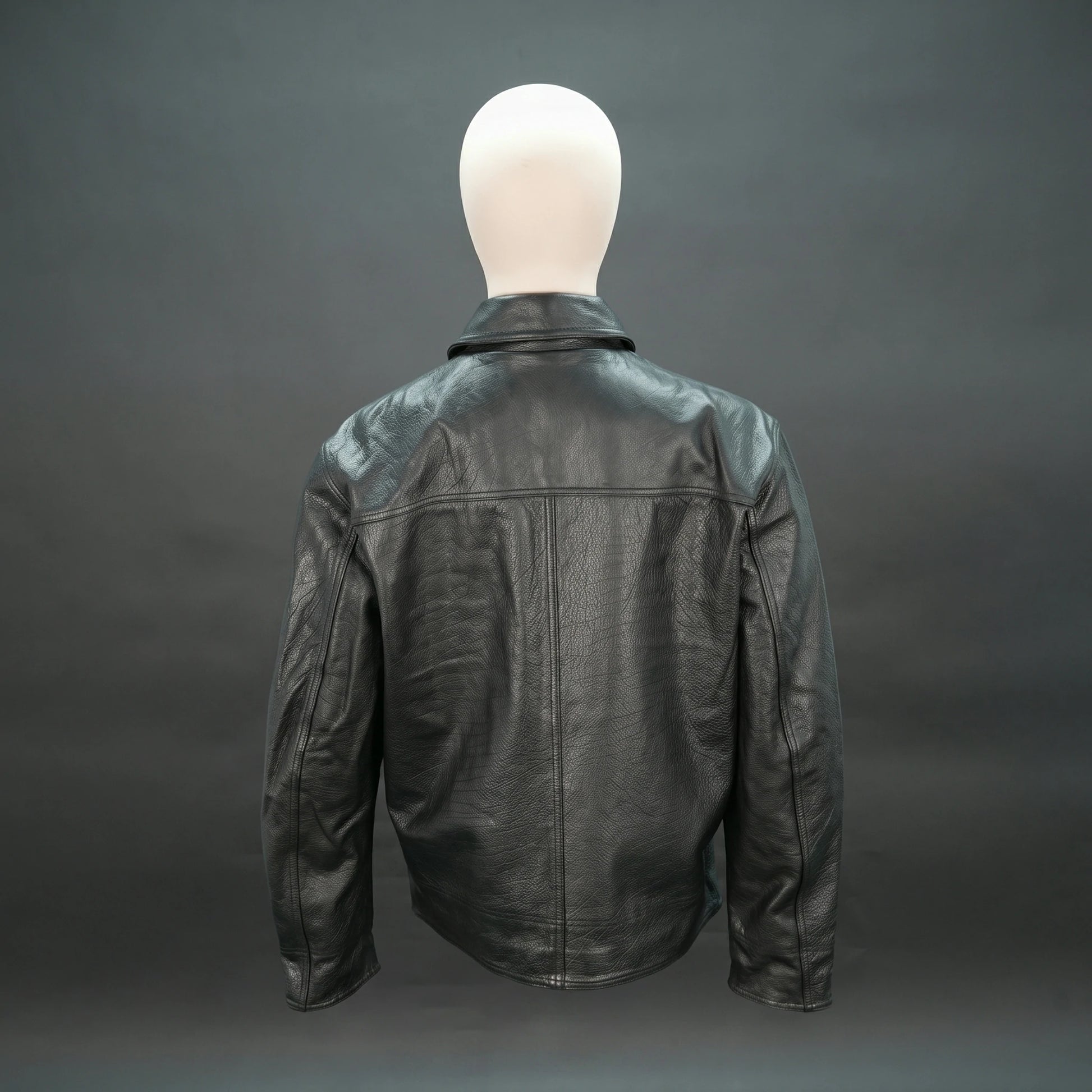 Black leather jacket with spread collar, button closure, and relaxed fit.