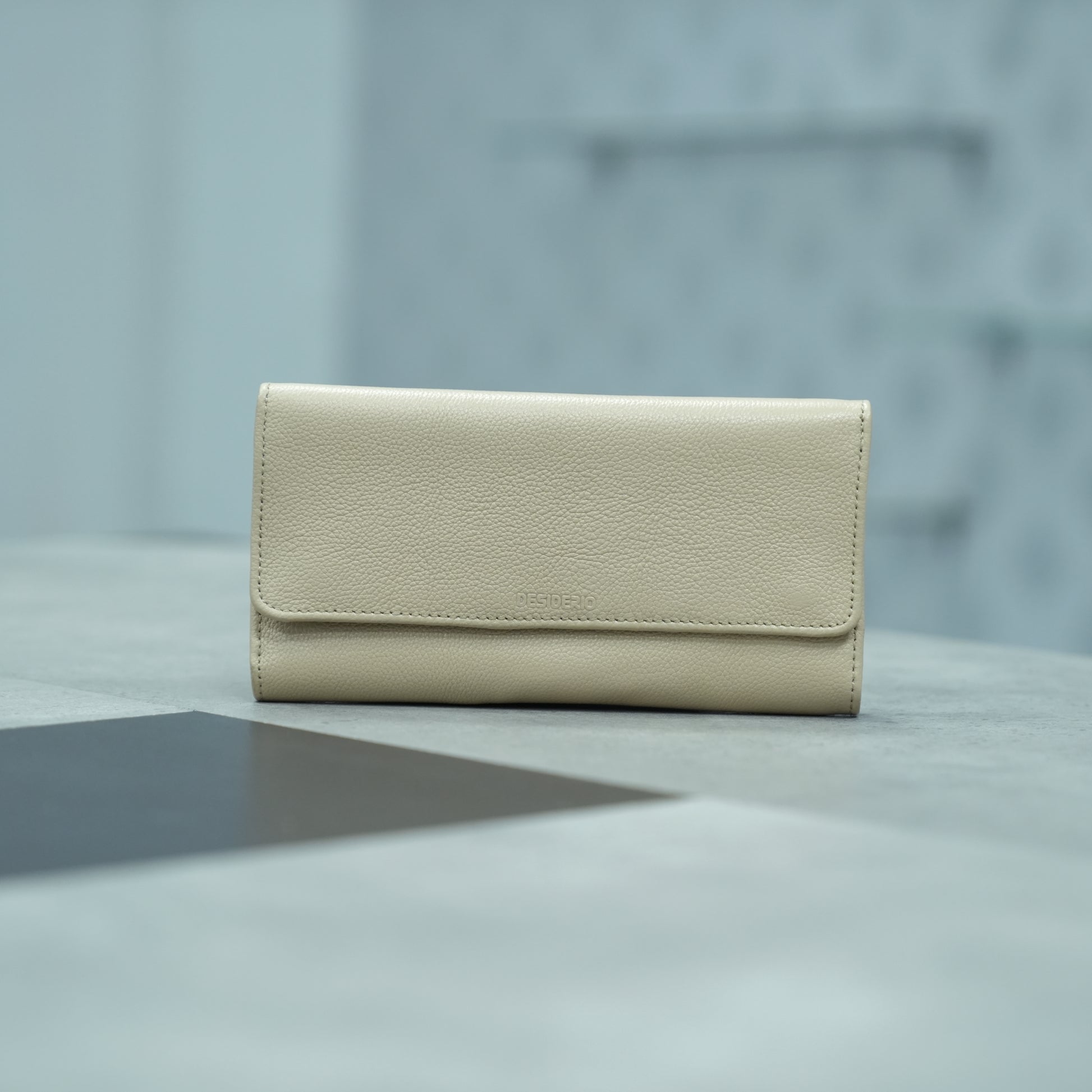 Beige leather clutch with two open pockets, one zip pocket, and eleven card slots
