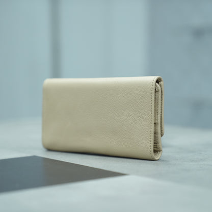 Beige leather clutch with two open pockets, one zip pocket, and eleven card slots