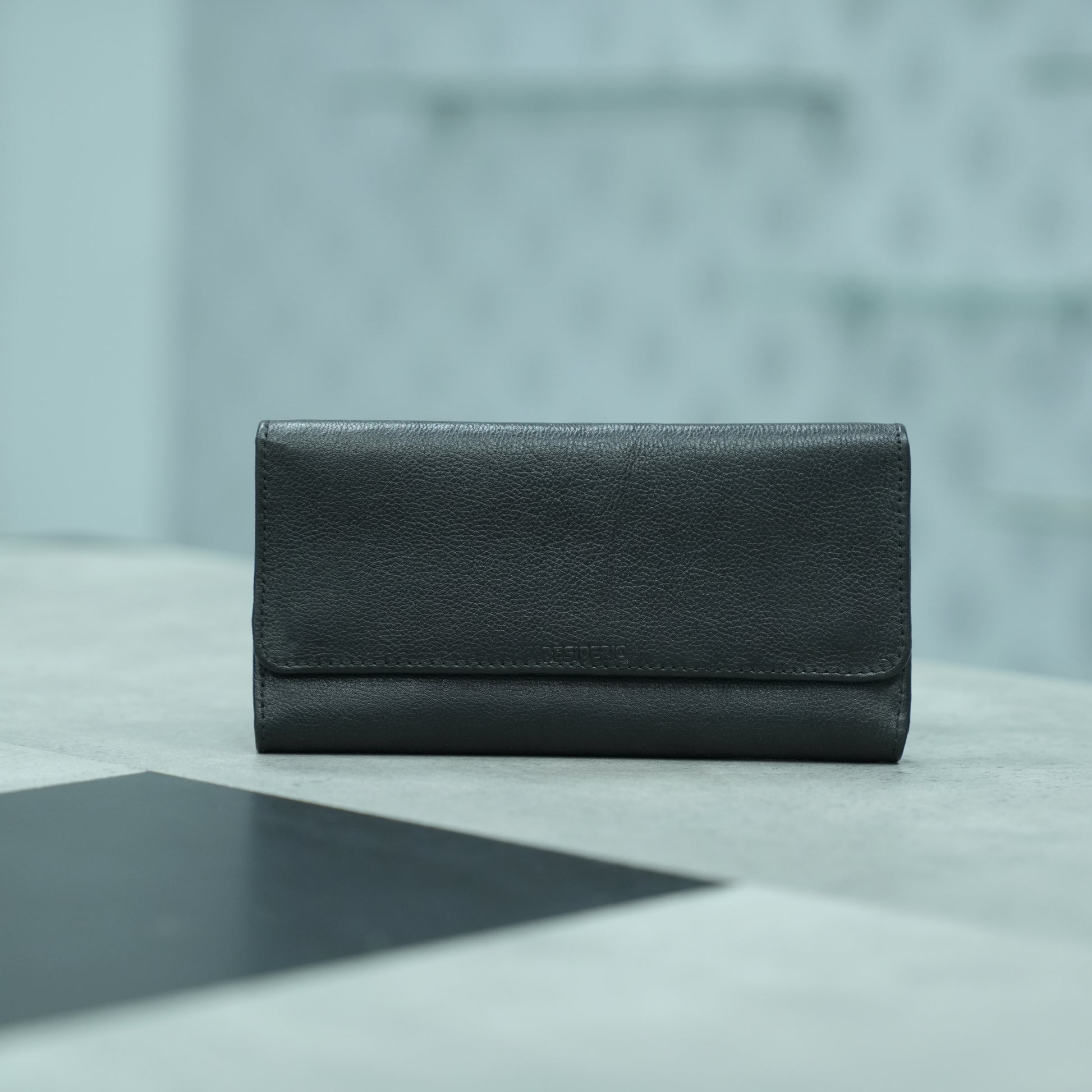 Black leather clutch with two open pockets, one zip pocket, and eleven card slots for organized storage