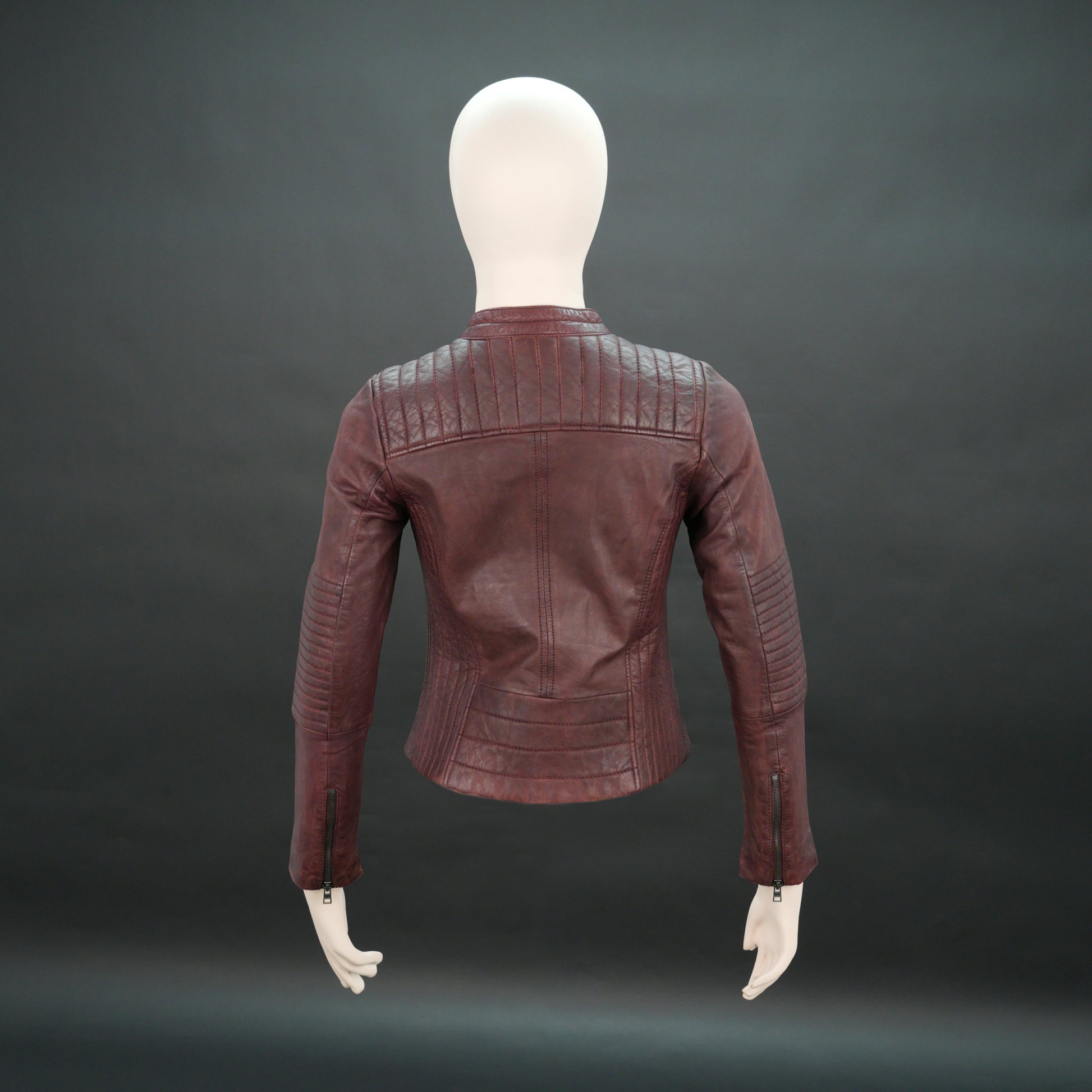 Women maroon leather biker jacket with quilted shoulders and front zip.