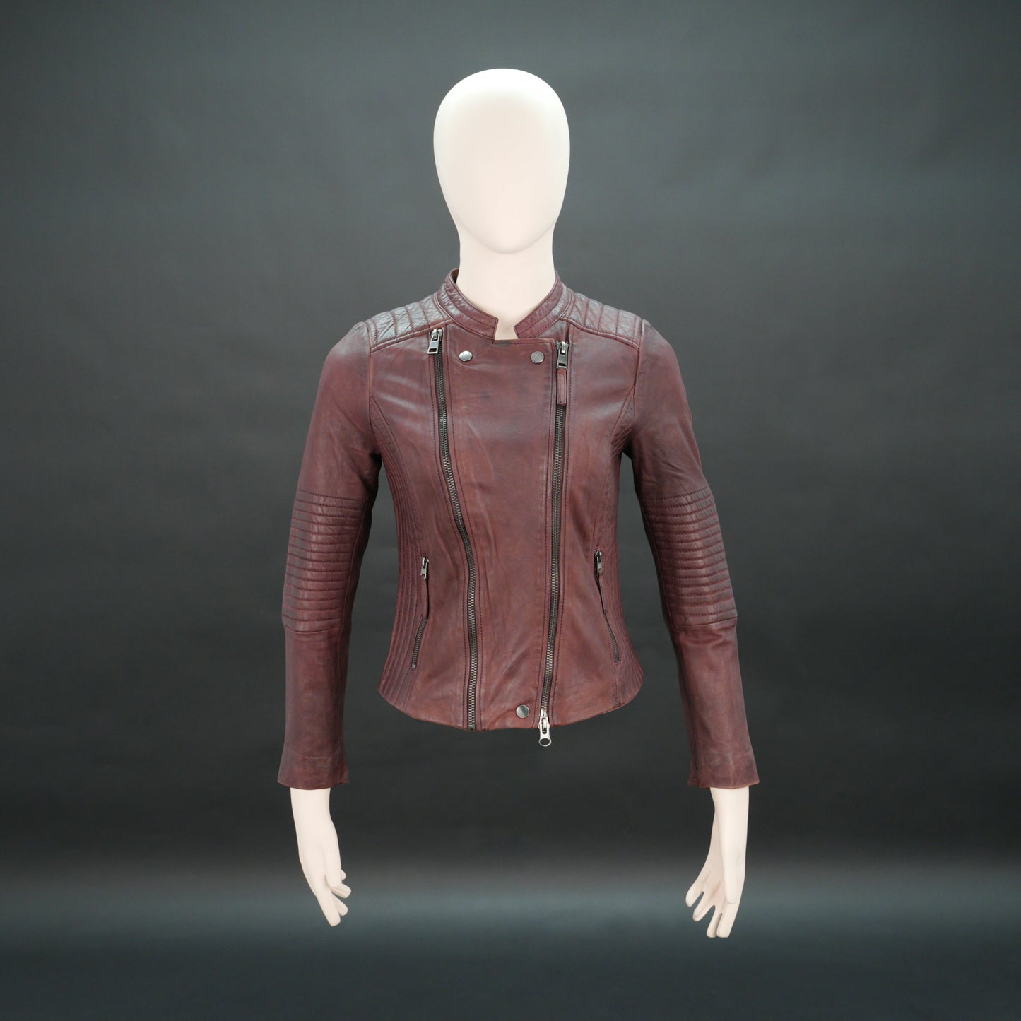 Women maroon leather biker jacket with quilted shoulders and front zip.