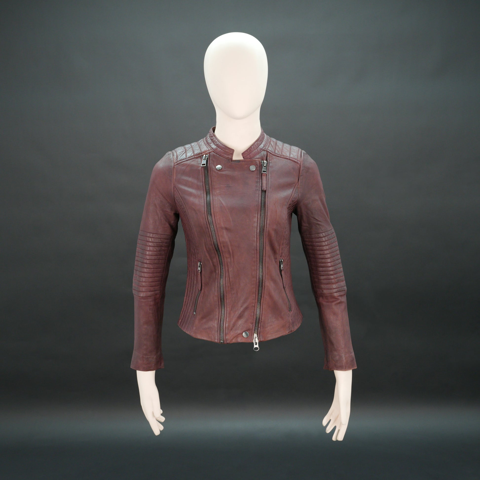 Women maroon leather biker jacket with quilted shoulders and front zip.