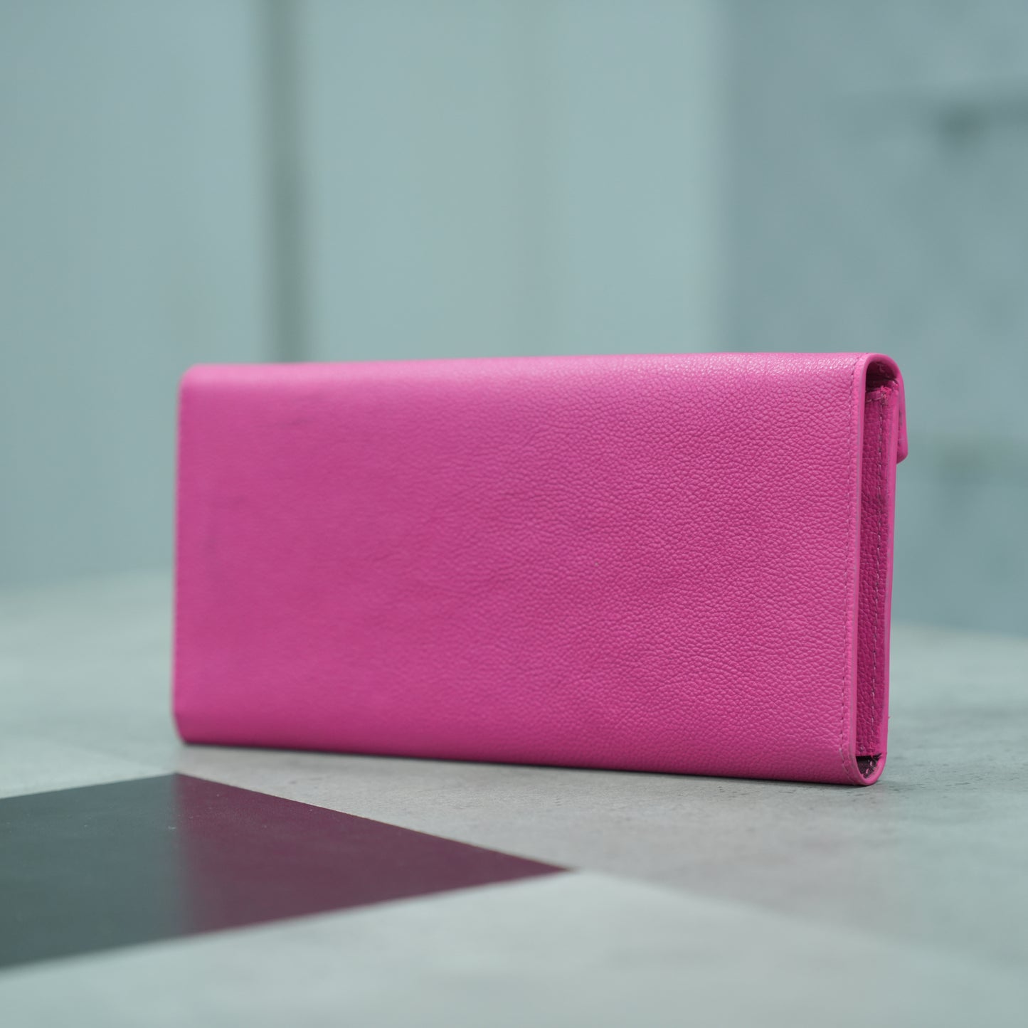 Pink leather clutch with three main compartments, one zip pocket, and three card pockets for organized storage