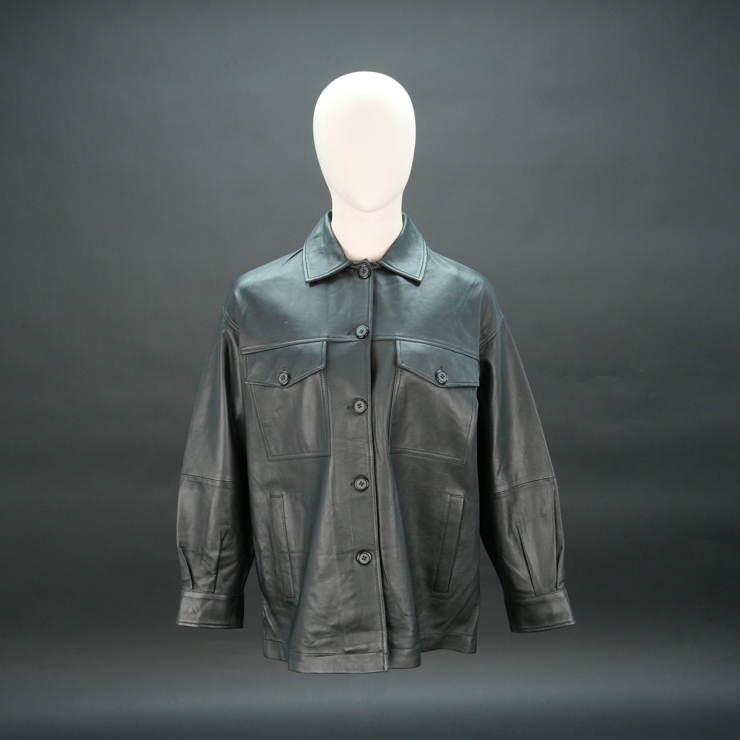 Black leather jacket with button closure, flap pockets, and relaxed fit.