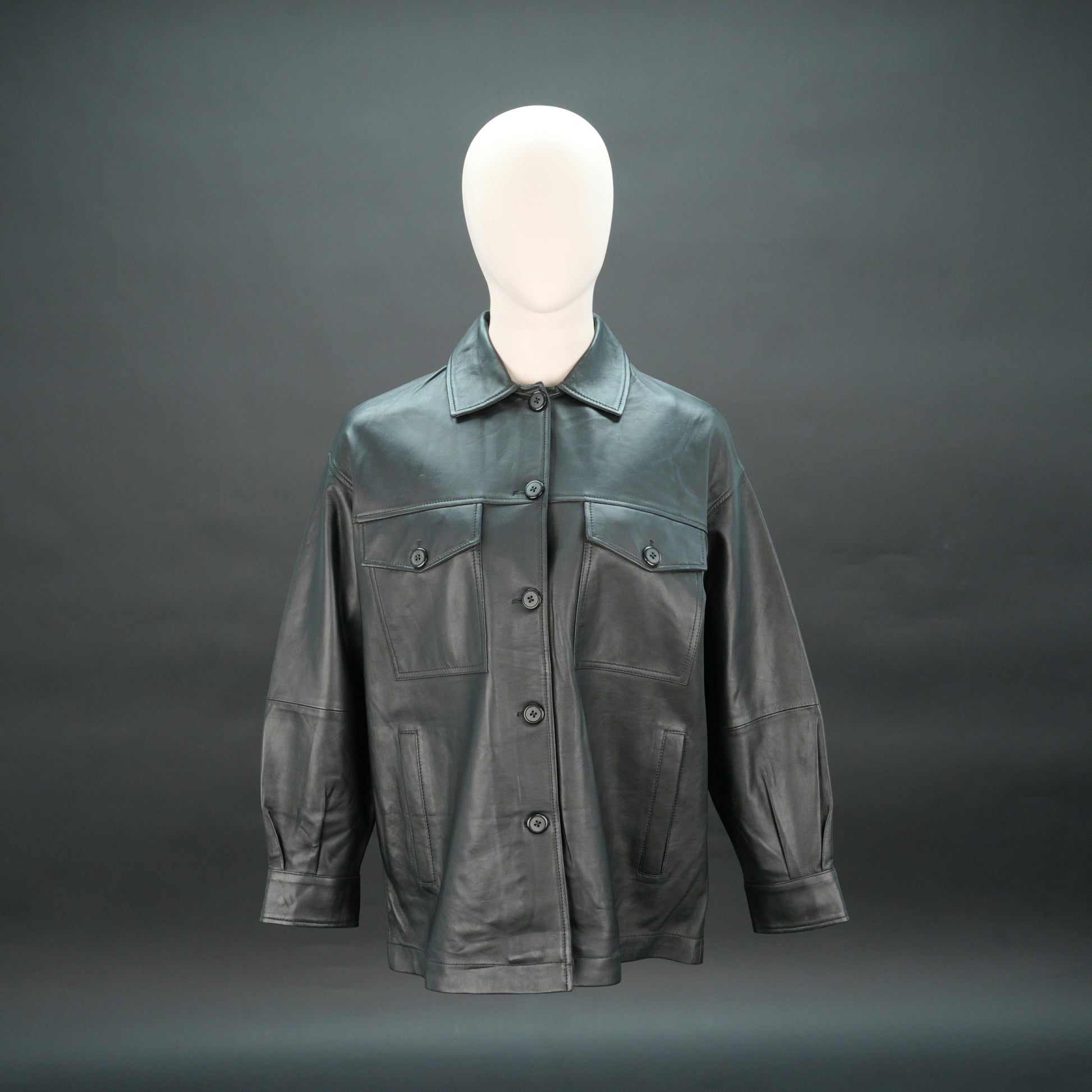 Black leather jacket with button closure, flap pockets, and relaxed fit.