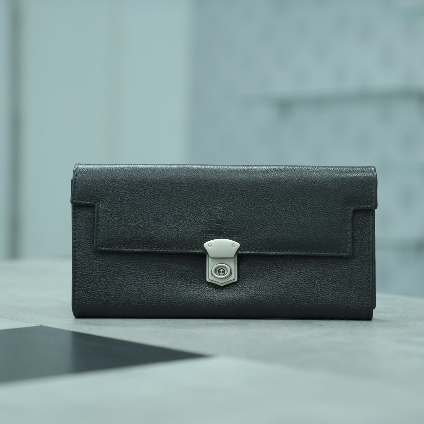 Black leather clutch with three compartments, sixteen card slots, a zip pocket, cash compartment, and key for security