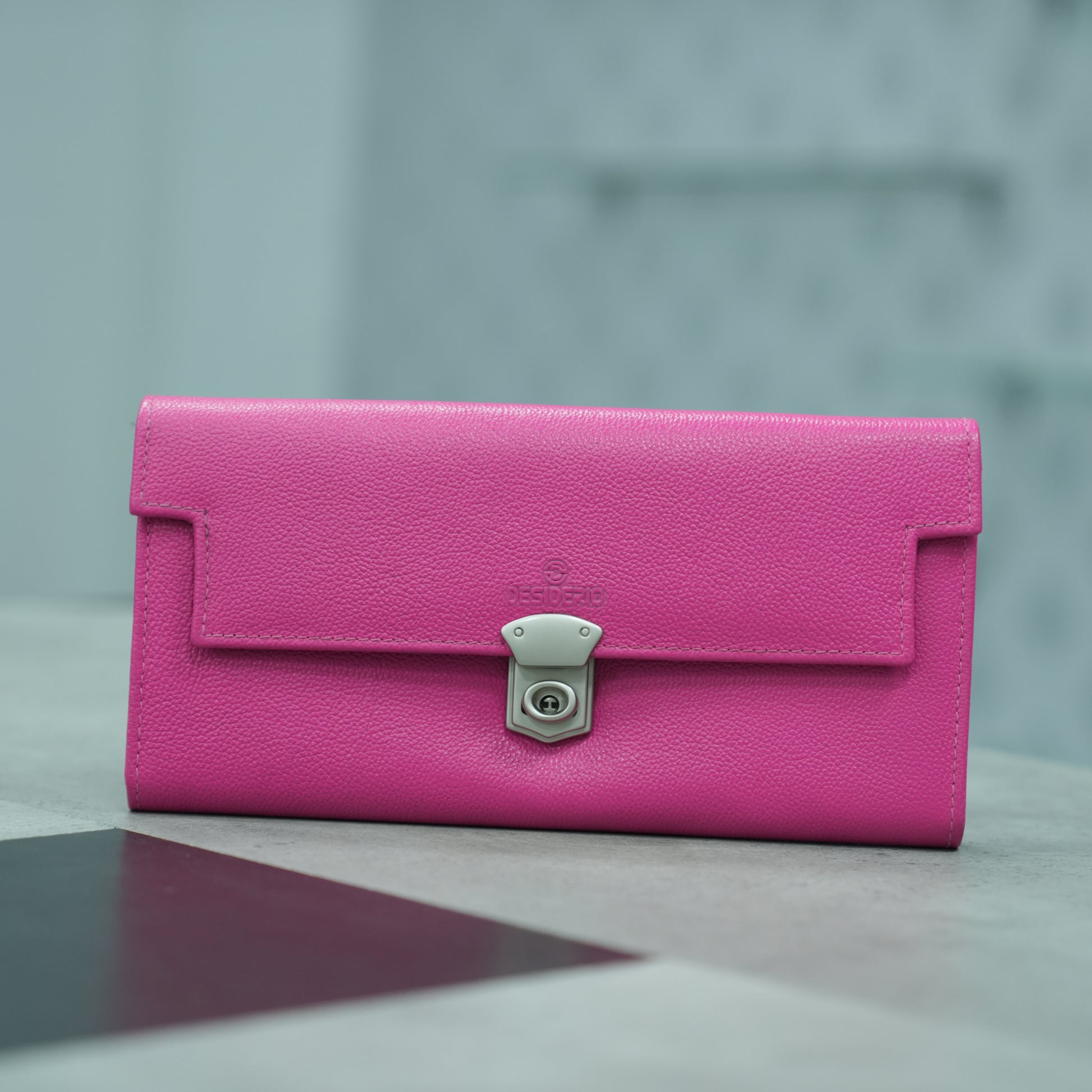 Pink leather clutch with three compartments, sixteen card slots, a zip pocket, cash compartment, and key for security