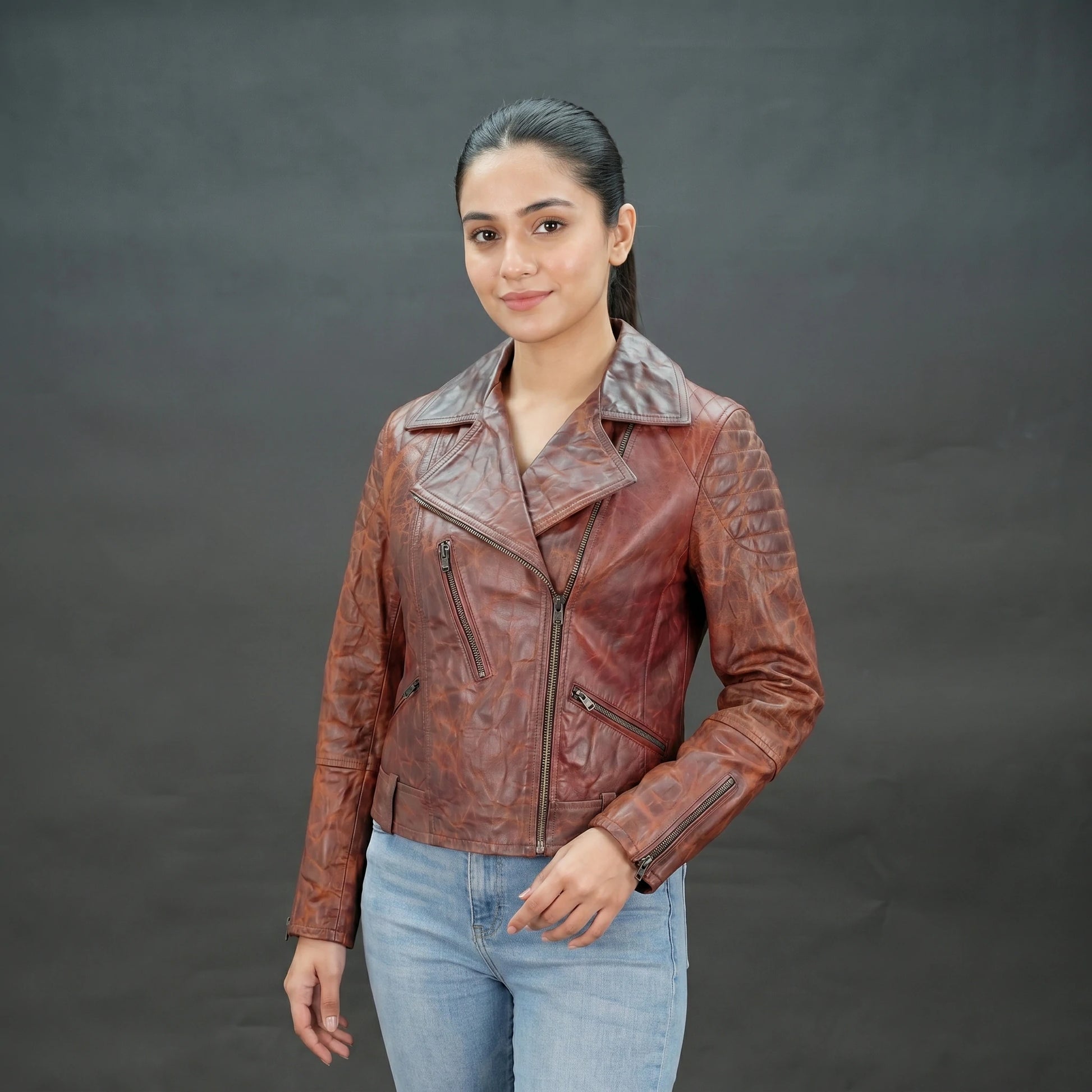 Reddish-brown distressed leather biker jacket with asymmetrical zip.