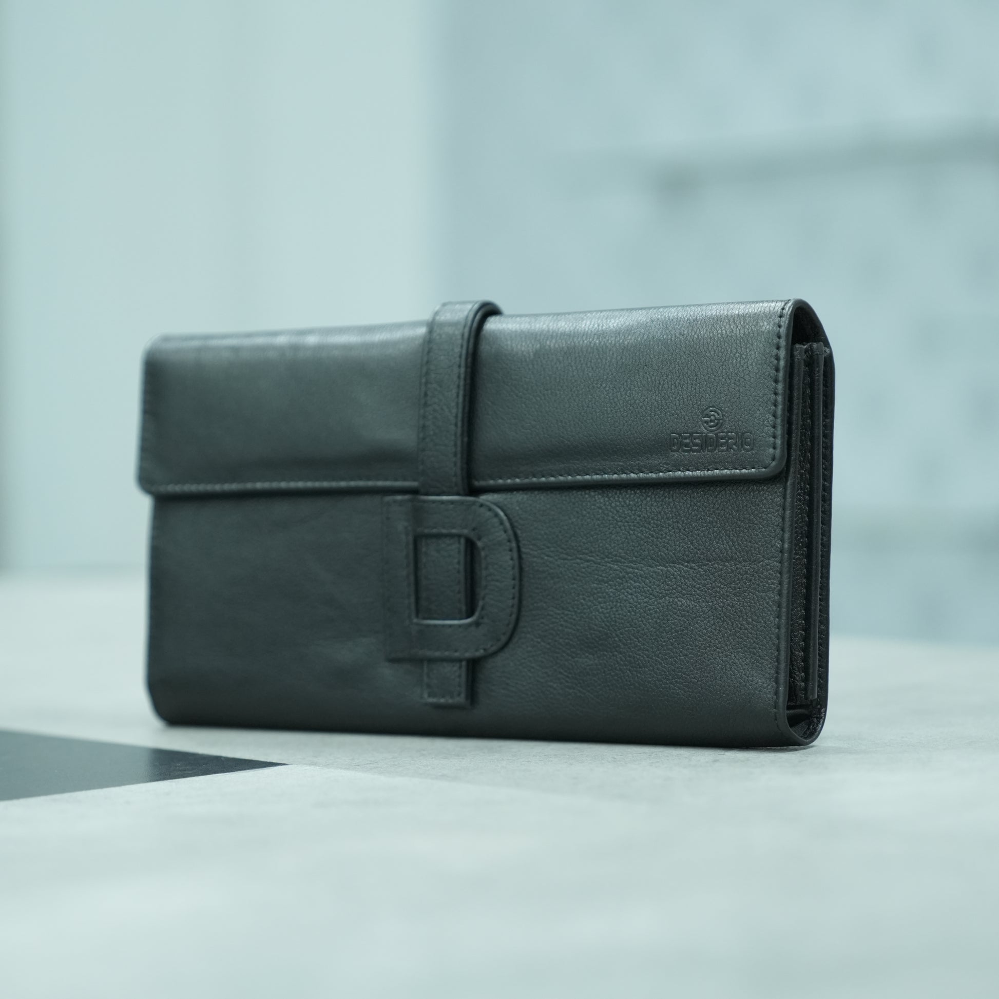 Black leather mini clutch with three compartments, sixteen card slots, and zip pocket, compact and elegant