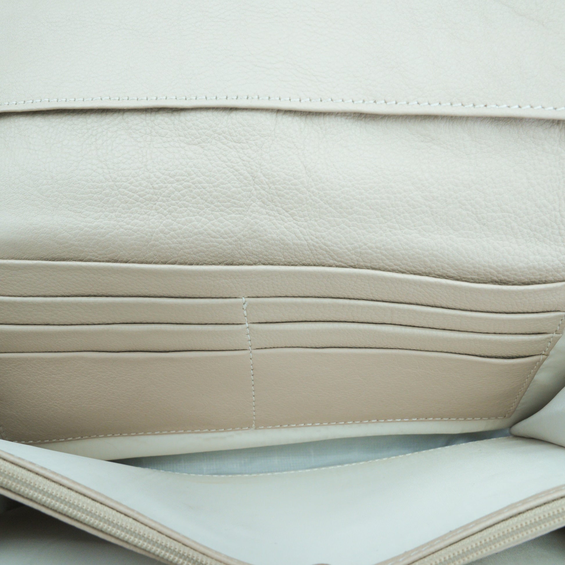 Beige leather mini clutch with three compartments, sixteen card slots, and a zip pocket