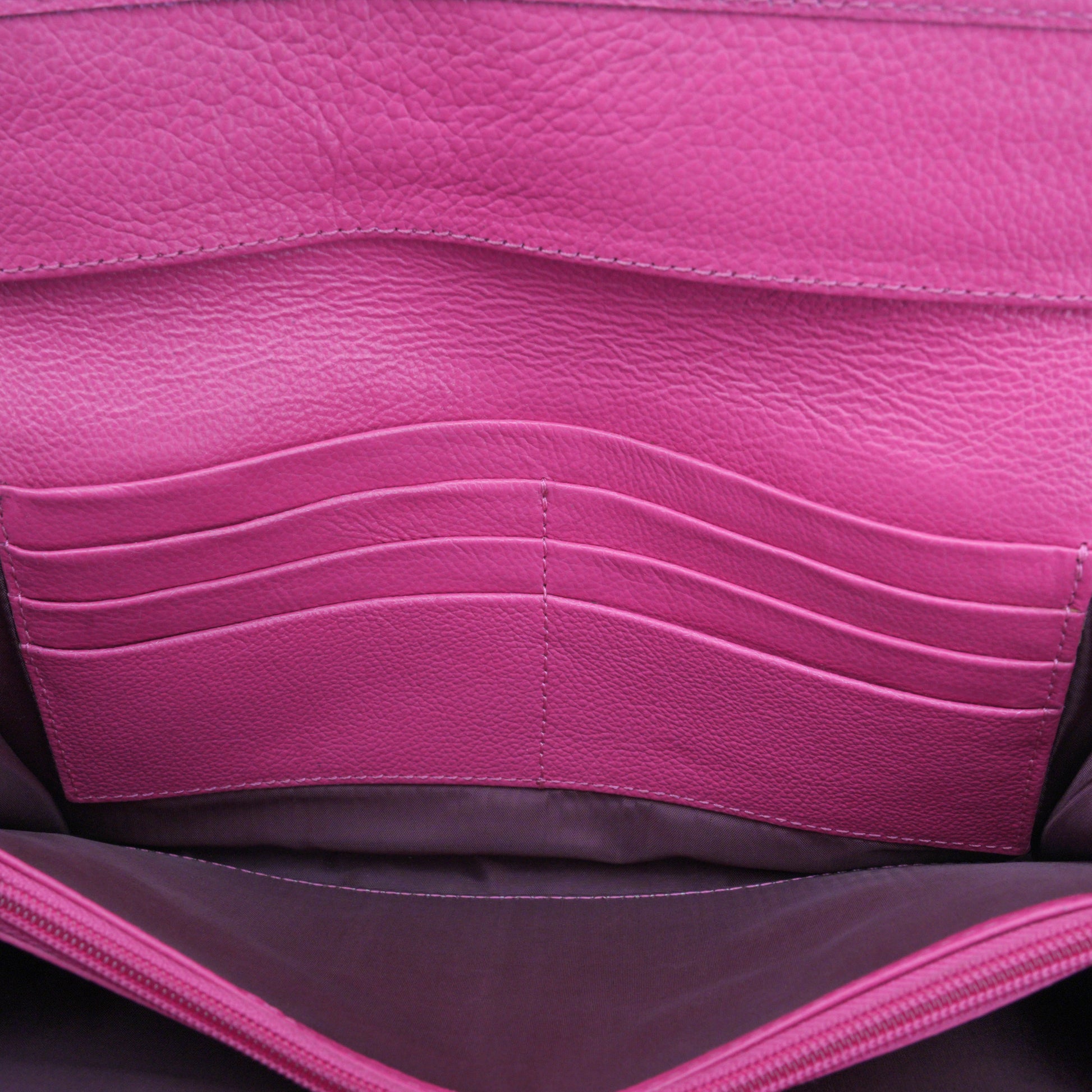 Compact pink leather mini clutch with three compartments, sixteen card slots, and zip pocket, combining sleek design with everyday functionality