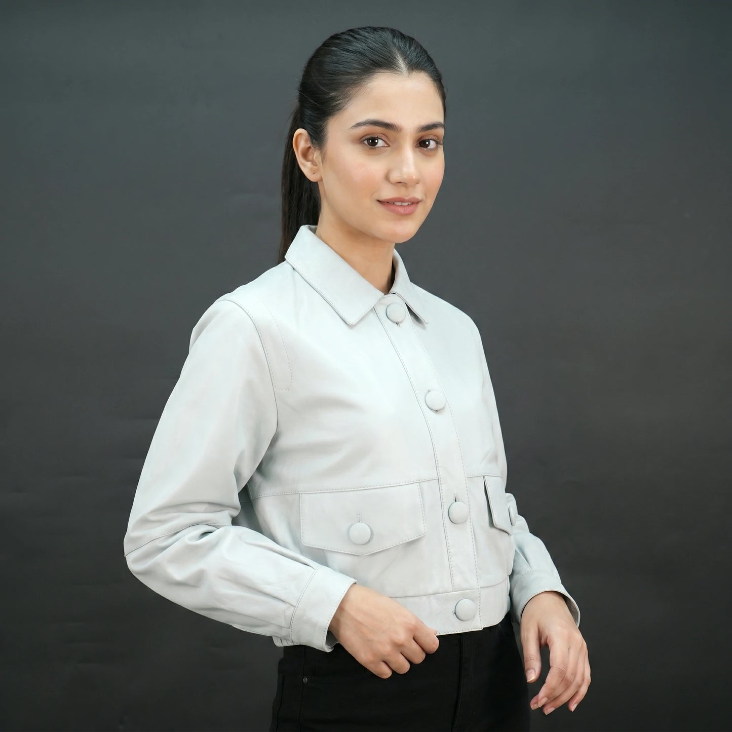 White cropped leather jacket with shirt collar and flap pockets.