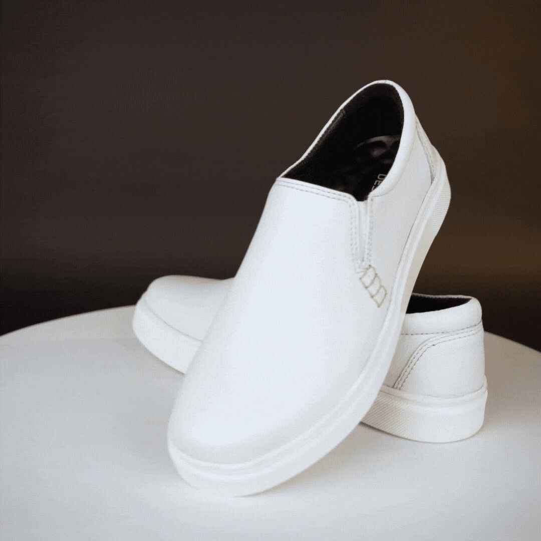 White slip-on sneakers crafted from premium Cow Chelsia leather with soft sheep leather lining, non-woven insole, and durable TPR sole—comfortable, flexible, and suitable for both formal and casual occasions.